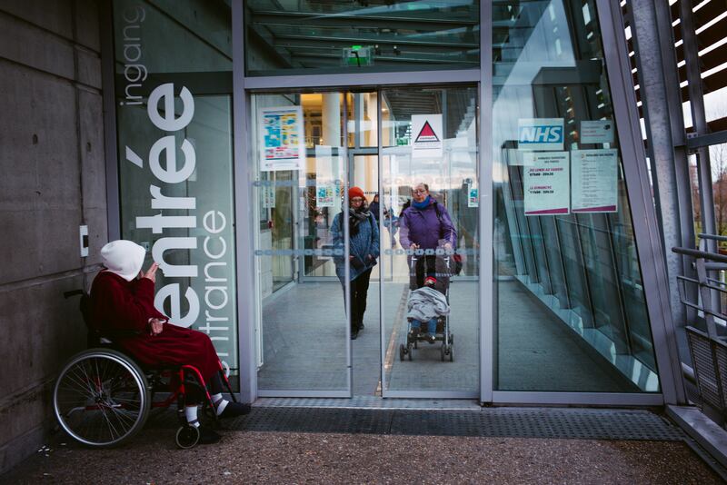 The entrance to the Calais Hospital features a flier for the NHS, which has been quietly outsourcing some of its surgeries to three hospitals in France.