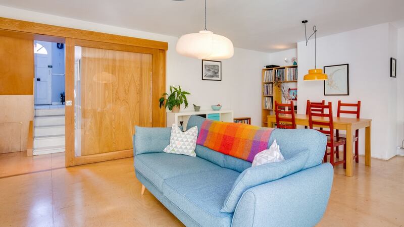 A large glass and oak framed sliding door  closes the living room from the hall.