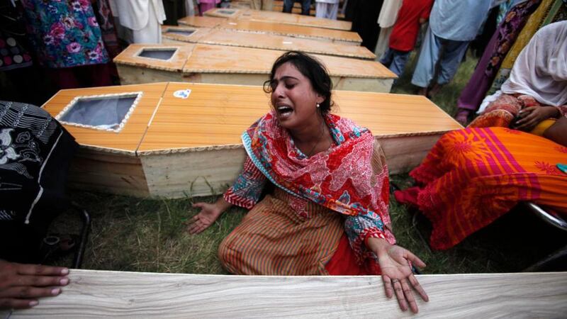 A Christian woman mourns next to the coffin of her brother, who was killed in the  suicide attack. Photograph: Reuters.