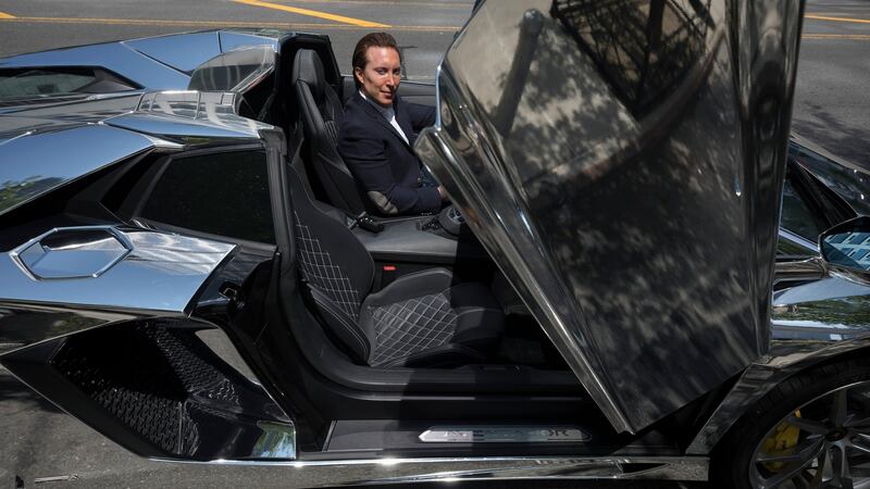 Real estate broker Daniel Neiditch in a Lamborghini, one of three luxury cars he is offering as part of the sale of the  Manhattan condominium. Photograph:  James Estrin/The New York Times