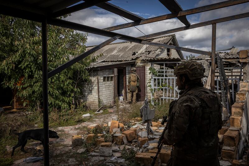 Fighters with the volunteer Carpathian Sich battalion search a house used by Russian soldiers in the recaptured village of Stavky, Ukraine, on October 5th. Photograph: Ivor Prickett/New York Times