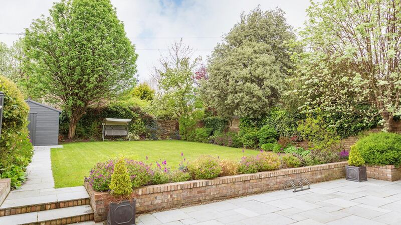 The walled rear garden has a stone-paved patio, good lawn,  fruit, Birch and holly trees and lavender plants