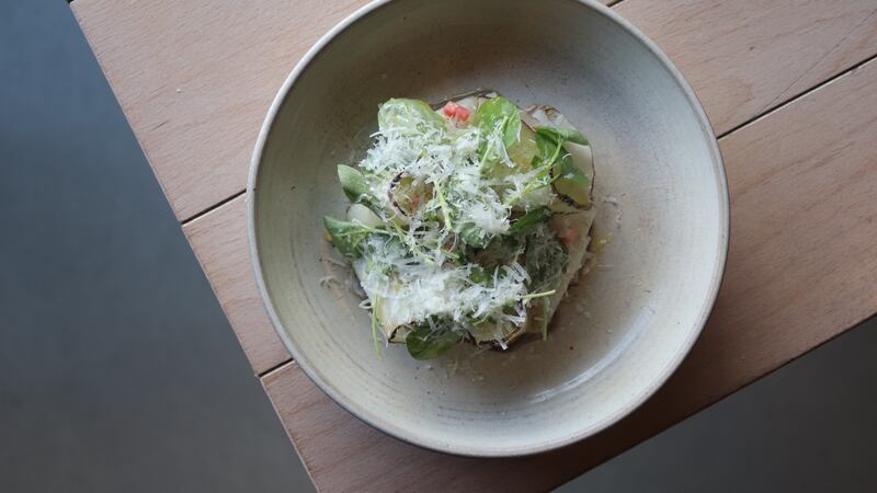 Discs of celeriac are gently folded and layered on top of a silky sunflower seed mole