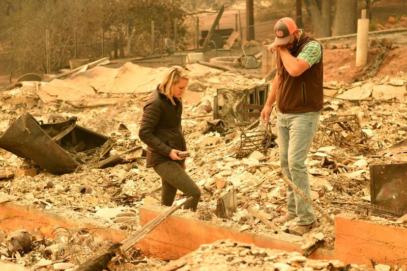 Chris and Nancy Brown  look over the remains of their burned residence after the Camp fire tore through  Paradise, California on Monday. More than 200 people are still unaccounted for, according to officials. Photograph: AFP