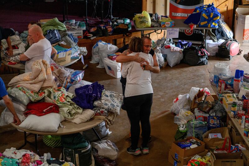 A hug is exchanged as supples are distributed to residents after heavy flooding at Cross Kingdom Church in Kerrville, Texas. Photograph: Callaghan O’Hare/The New York Times
                      