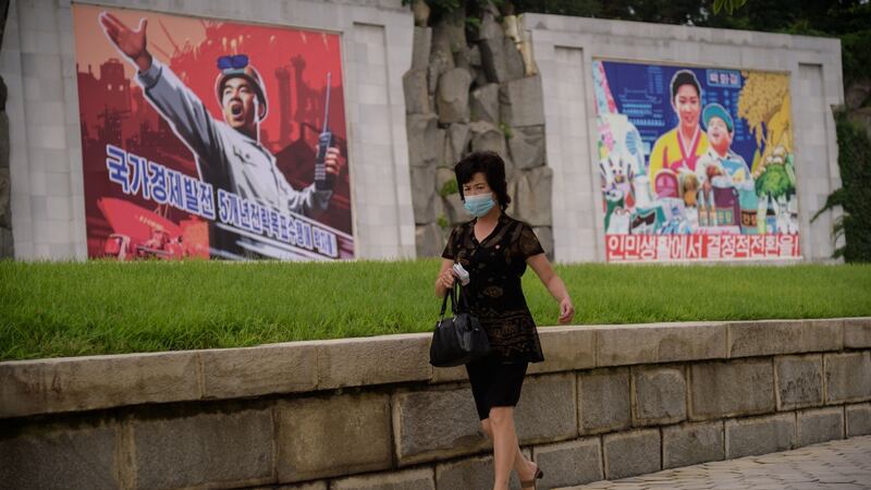 A woman walks past propaganda posters displayed on a street in central Pyongyang.  Photograph: Kim Won-jin/AFP via Getty Images