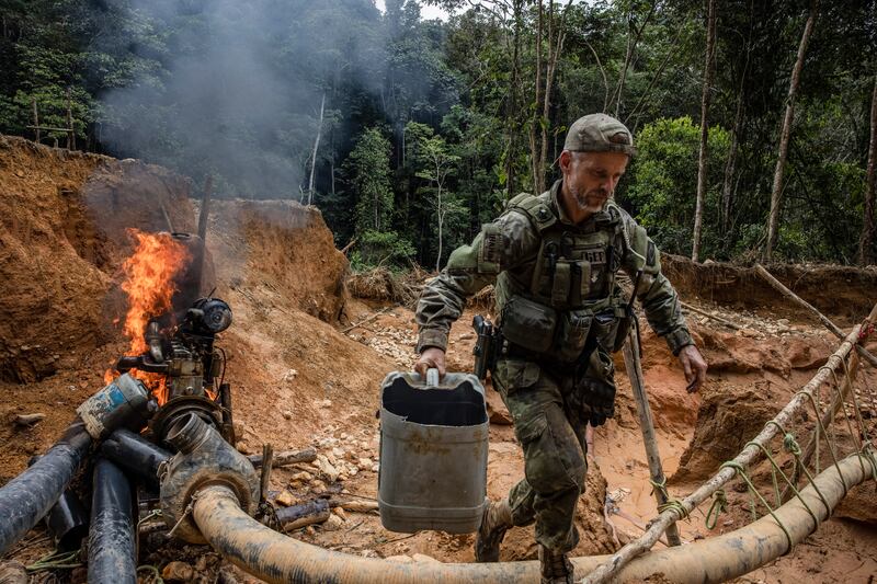 Felipe Finger, the head of Brazil’s environmental special forces team, burning a water pump at an illegal mine in the Yanomami Indigenous territory of Brazil. Photograph: Victor Moriyama/The New York Times
                      