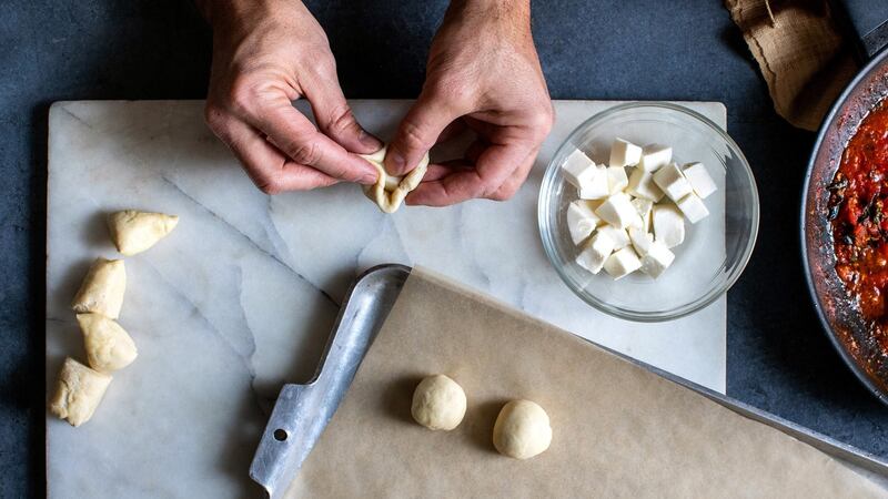 Bread dough is wrapped around a chunk of mozzarella. Photograph: Andrew Scrivani/The New York Times