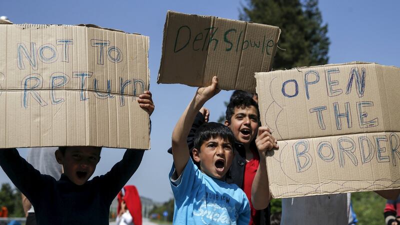 Migrants and refugees shout slogans as they block the highway near the Greek-Macedonian border near the village of Evzoni, Greece. Photograph: Marko Djurica/Reuters