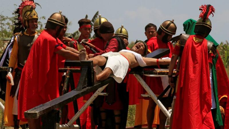 Ruben Enaje, who is portraying Jesus Christ for the 31st time, grimaces as he is nailed on a wooden cross during a Good Friday crucifixion re-enactment in Cutud village. Photograph: Romeo Ranoco/Reuters