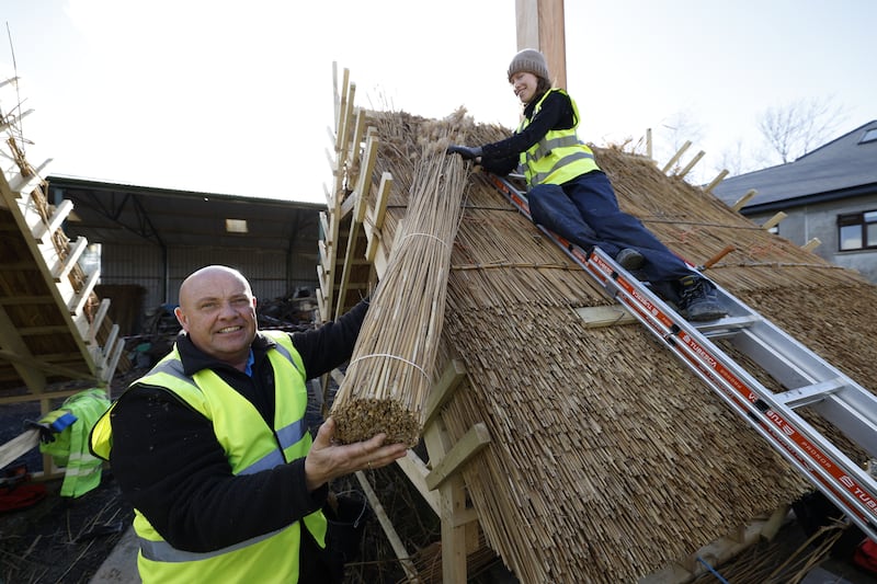 Brian Simpson working with student Alice Bowler from Wexford, thatching in the group of tighins at Gáirdín an Ghorta in Sheepstown, Co Kilkenny. Photograph: Nick Bradshaw
