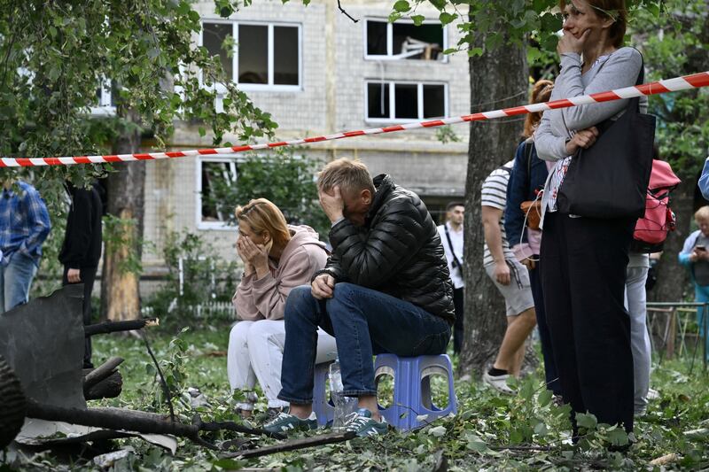 Residents react as Ukrainian rescuers conduct search-and-rescue work following a Russian missile strike in Kyiv. Photograph: Genya Savilov/AFP/Getty Images          