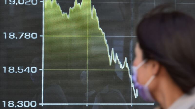 A pedestrian looks at a display showing movement of share prices on the Tokyo Stock Exchange after US president Donald Trump announced measures to tackle coronavirus.  Photograph: Kazuhiro Nogi AFP via Getty Images