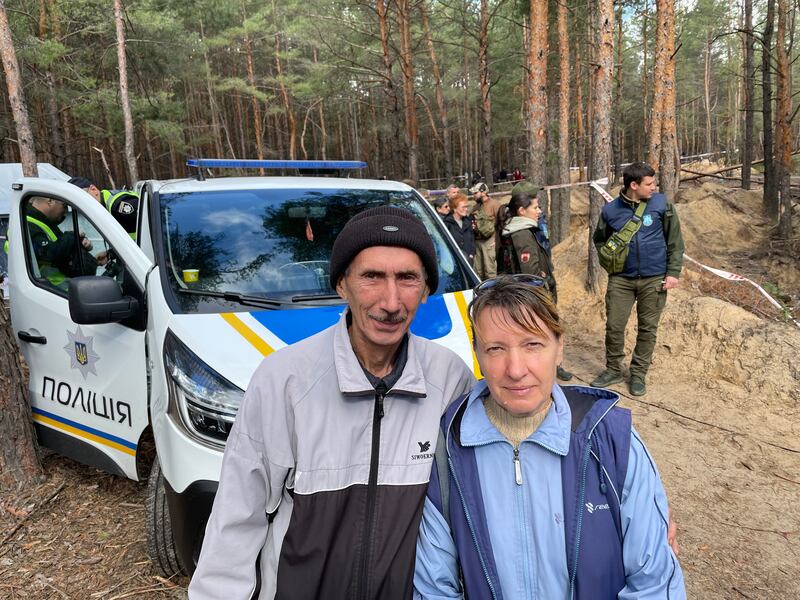 Natalia Zhernova and husband Mykola near a mass grave in Izyum, where she believes her mother-in-law was buried during Russia's five-month occupation. Photograph: Daniel McLaughlin