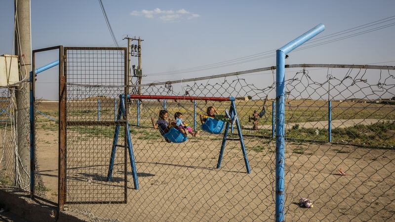 Youths play on swings at Roj Camp for the families of Islamic State members in Kurdish-controlled northern Syria. Photograph:  Ivor Prickett/The New York Times