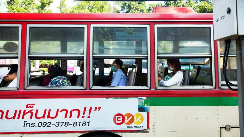 Some passengers on a bus in Bangkok, Thailand,  wearing facial masks