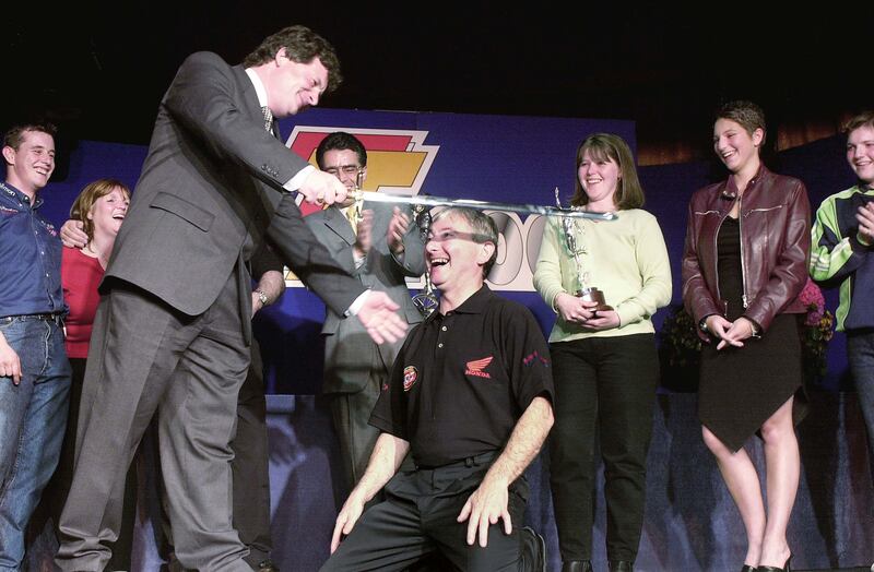 Arise Sir Joey! Joey Dunlop’s victory in the 250cc Lightweight TT racein 2000 marked his 25th TT win, a feat that was honoured with the presentation of the Isle of Man’s Sword of State by the Minister for Sport, David Cretney during the prize giving ceremony as Joey’s family and Honda teammate, John McGuinness, looked on. Photograph: Stephen Davison
                  