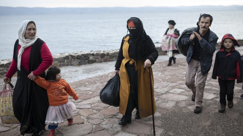 Migrants from Afghanistan walk ashore after their arrival near Eftalo in Lesbos, Greece, on Sunday. Photographer: Konstantinos Tsakalidis/Bloomberg