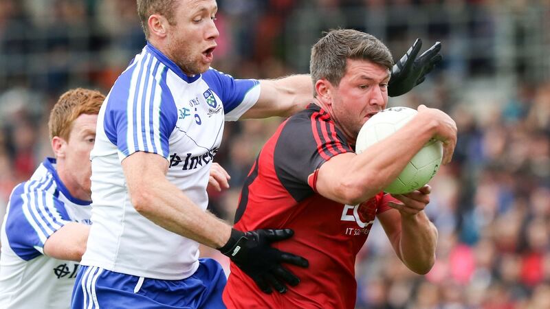 Down’s Peter Turley holds on as Vinny Corey of Monaghan tackles him. Photograph: Inpho