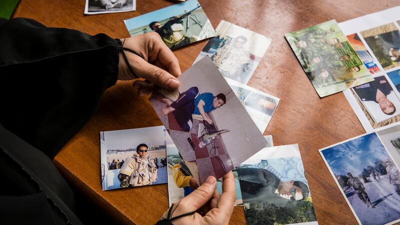 Captain Sudani’s wife Raghad Chaloob looks at photographs of her late husband at her home in Baghdad. Photograph:  Ivor Prickett/The New York Times