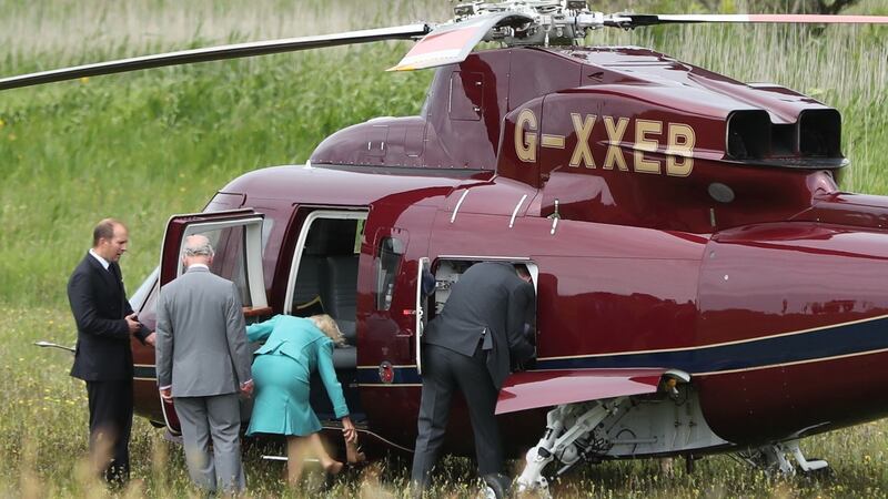 The Duchess of Cornwall shakes sand from her shoes as she and the Prince of Wales get into a helicopter after walking on Derrynane beach in Co Kerry. Photograph: Niall Carson/PA