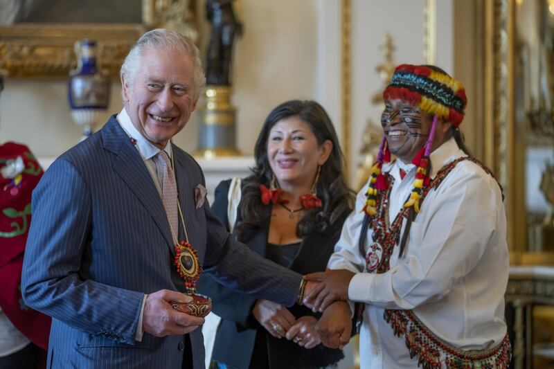 Amazon indigenous leader Domingo Peas (right) presents a gift to King Charles III during a reception at Buckingham Palace. The new portrait of Charles depicts him wearing a bracelet given to him by Mr Peas. Photograph: Kin Cheung/PA