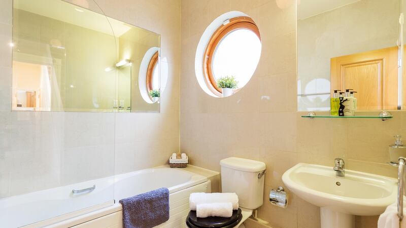 The bathroom has a rather smart round window that brings in a good deal of natural light