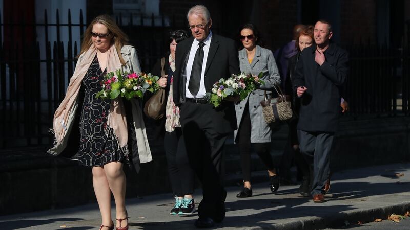 Mourners carry floral tributes to the  Pro-Cathedral in Dublin on Wednesday. Photograph: Niall Carson/PA Wire