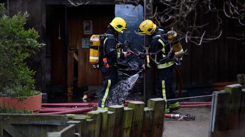 Firefighters spray each other down before entering an area to survey the damage after a fire destroyed a number of buildings at London Zoo on December 23rd, 2017. Photograph:  Leon Neal/Getty Images