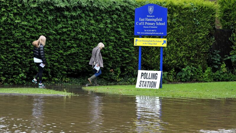 People make their way along a flooded path as they arrive to vote in the EU referendum at the polling station in East Hanningfield, Essex, as torrential downpours and flooding have swamped parts of London and the southeast. Photograph: Nick Ansell/PA Wire