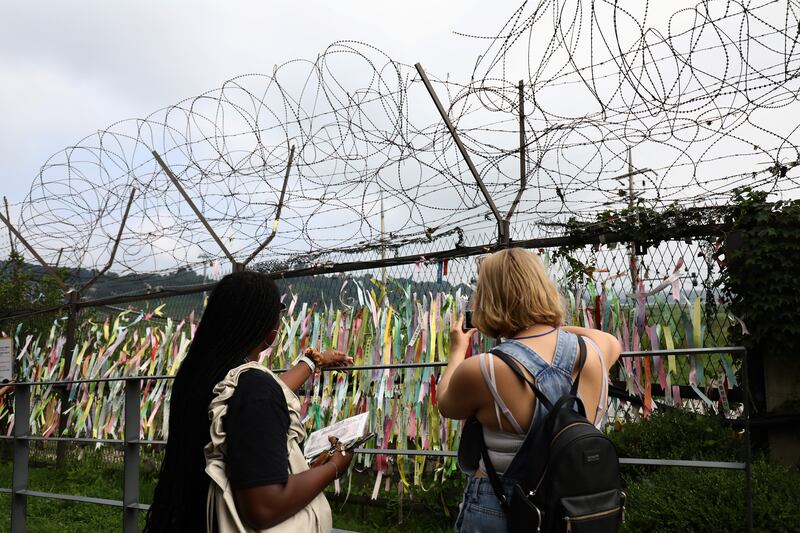 Tourists take pictures of prayer ribbons wishing for reunification of the two Koreas on the wire fence at the Imjingak Pavilion, near the demilitarised zone in Paju, South Korea. Photograph: Chung Sung-Jun/Getty Images