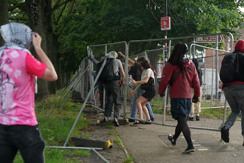 Protesters take down fencing on the Grand Canal that was erected to prevent tents being pitched.  Photograph: Enda O'Dowd