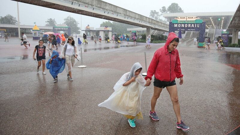 People leave Disney’s Magic Kingdom theme park, in heavy rain, after it closed in Orlando on Thursday. Some three million people on the US southeast coast faced an urgent evacuation order as monstrous Hurricane Matthew -- now blamed for more than 100 deaths in Haiti alone -- bore down for a direct hit on Florida. Photograph: Gregg Newton/AFP/Getty Images