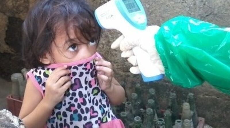Three-year-old Desiree Pajo has her temperature taken in Sitio Marna