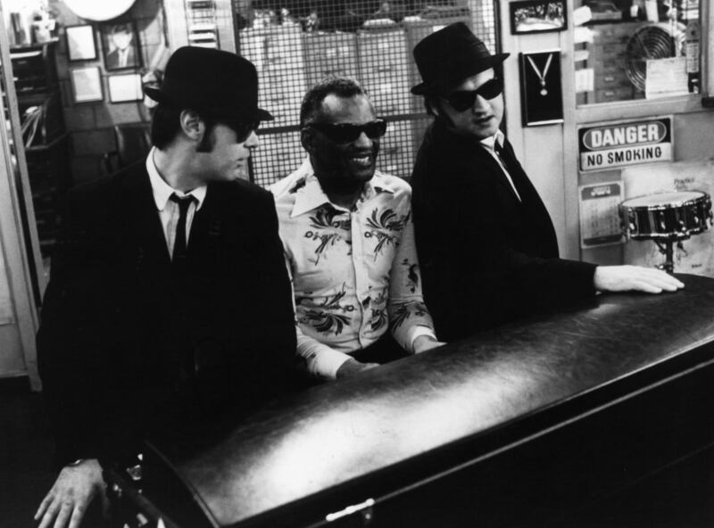Dan Aykroyd listens as Ray Charles plays piano next to John Belushi in a scene from the film. Photograph: Universal Pictures/Getty