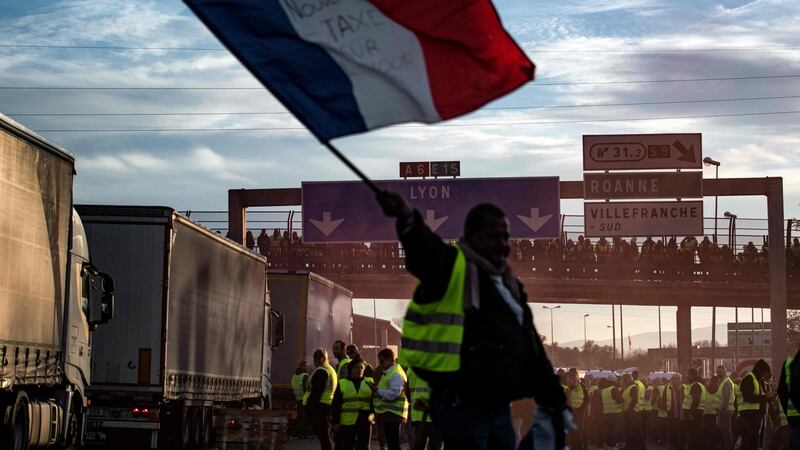 A “yellow vest”  protester waves a French flag on the A6 motorway in Villefranche-sur-Saone on Saturday. Photograph: Jeff Pachoud/AFP/Getty Images