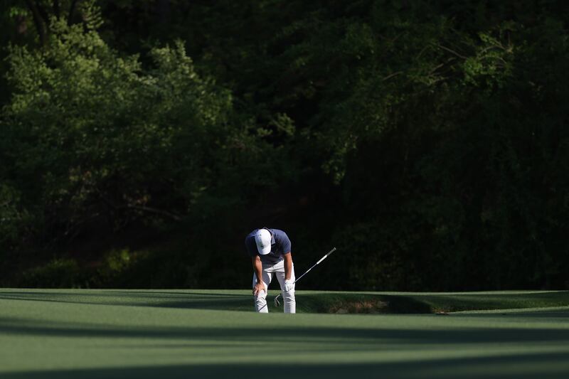 Disaster: McIlroy reacts after his third shot on the 13th hole goes in the creek. He drops two shots following a chip from a drop and two putts. Moments later Justin Rose birdies 16 to draw level on 11 under.  Photograph: Andrew Redington/Getty Images