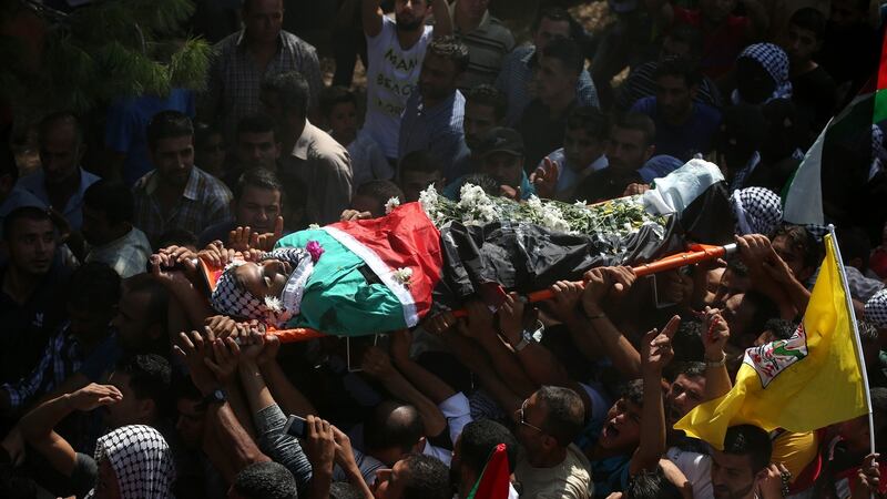 Mourners carry the body of Iyad Al Awawdeh during his funeral in the West Bank village of Yatta, near Hebron. He  was shot and killed during a protest in Hebron when he was pretending to be a local news photographer, wearing a t-shirt marked with ‘PRESS’, as he advanced and stabbed the Israeli soldier. Photograph: EPA