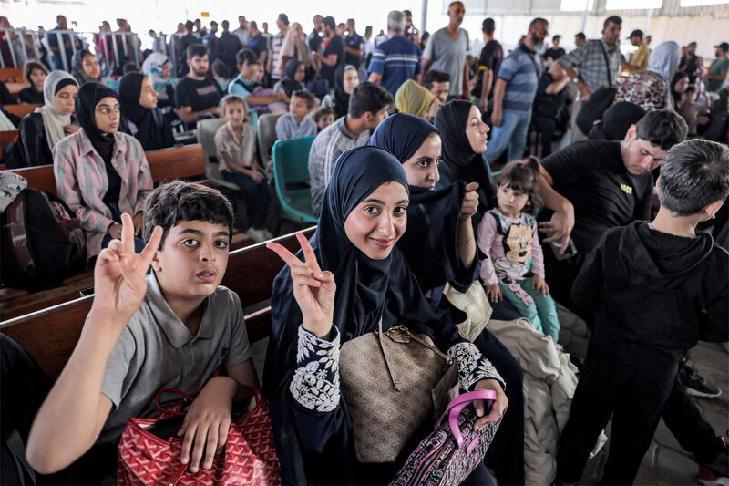 People sit in the waiting area at the Rafah border crossing in the southern Gaza Strip before crossing into Egypt. Scores of foreign passport holders trapped in Gaza started leaving the war-torn Palestinian territory. Photograph: Mohammed Abed/Getty Images