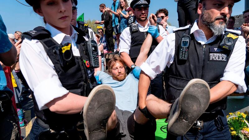 Police officers arrest and carry away a climate change activist from  Waterloo Bridge on April 21st. Photograph:  Niklas Halle’n / AFP
