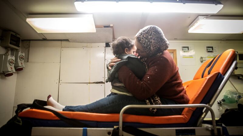 A pregnant woman holds her child as the Alan Kurdi pulls into the port of Pozzallo, Italy, on December 29th, 2019. Photograph: Sally Hayden