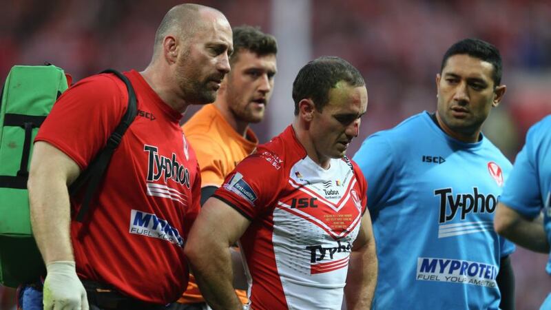Lance Hohaia (centre) of St Helens is helped off the field by medics after being punched by Ben Flower of Wigan Warriors, who was shown a red card during the First Utility Super League Grand Final   at Old Trafford. Photograph:  Michael Steele/Getty Images
