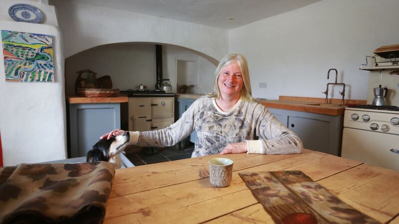 Nicola Brown and her dog Freddy  in the kitchen of her home, a traditional farmhouse in Carlow which she restored. Photograph: Laura Hutton