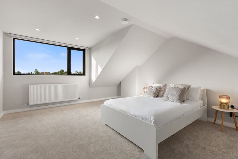 The attic is now a spacious fourth bedroom with ample headroom and a large dormer window looking out to the back