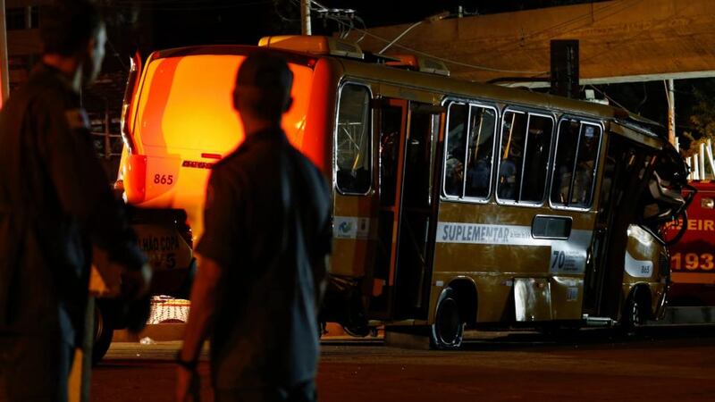 Police stand next to a bus trapped underneath a bridge that collapsed while under construction in Belo Horizonte, Brazil yesterday .Photograph: Ivan Alvarado/Reuters.