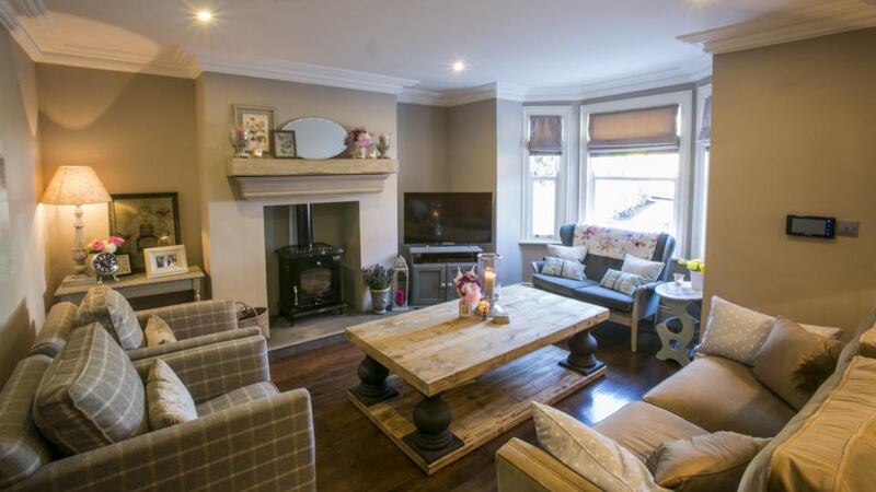 The cosy sitting room features a woodburning stove and a second-hand 1950s sofa. Photograph: Paul Kelly Photography
