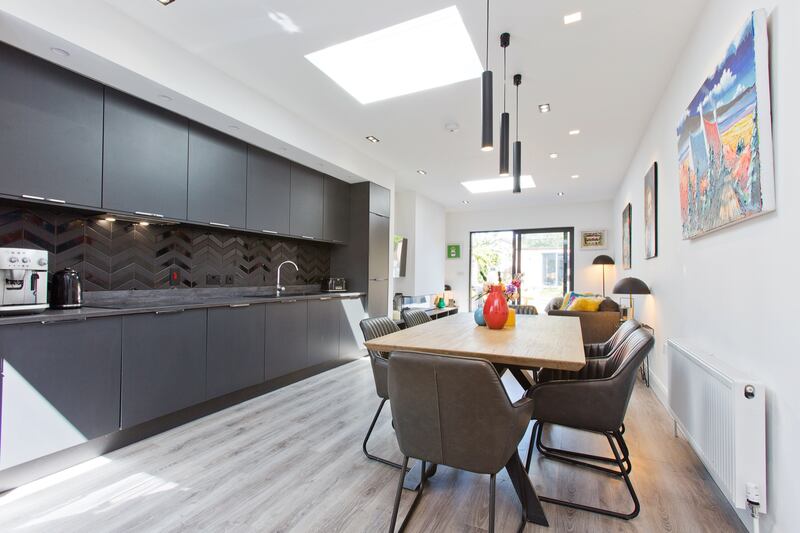 The anthracite-coloured kitchen and black metro-tiled splashback was made by Carndonagh Kitchens.