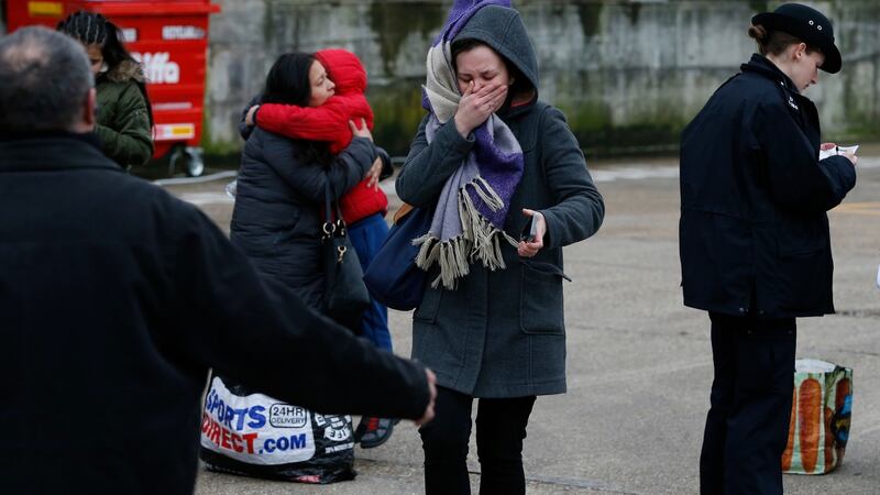 A woman reacts as police officers interview people near to the scene where a man was shot and killed by armed police in London. Photograph:  Hollie Adams/Getty Images