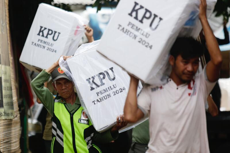 Electoral officers carry ballot boxes during distribution of materials to polling stations ahead of voting day in Depok, Indonesia. Photograph: Adi Weda/EPA