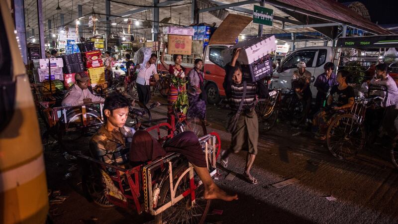 A bicycle porter checks his mobile phone outside a wholesale vegetable market in Yangon, Myanmar, in April 2017. Photograph: Roberto Schmidt/AFP/Getty Images